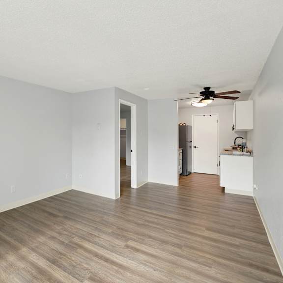 Thumbnail 13 of 13 A room with a wooden floor and a ceiling fan.