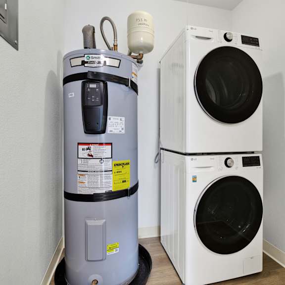 Thumbnail 6 of 13 A washing machine and a water heater in a room.