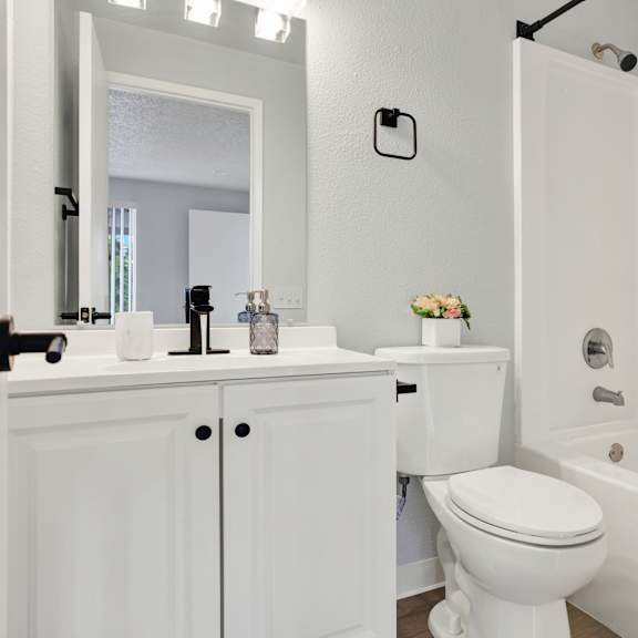 Thumbnail 11 of 13 A white toilet sits next to a white sink in a bathroom.