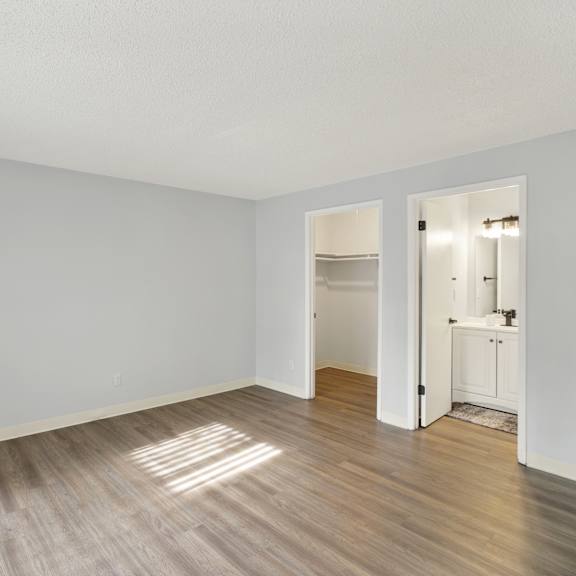 Thumbnail 7 of 13 A room with a white wall and a wooden floor.