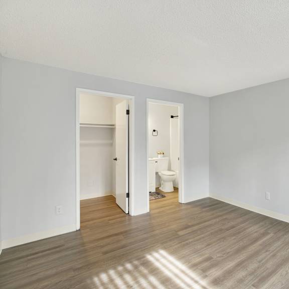 Thumbnail 9 of 13 A room with a wooden floor and white walls.