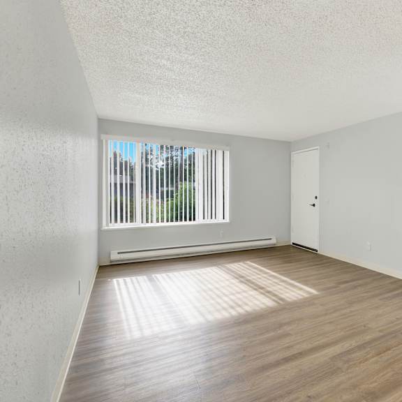 Thumbnail 12 of 13 A room with wooden floors and white walls.