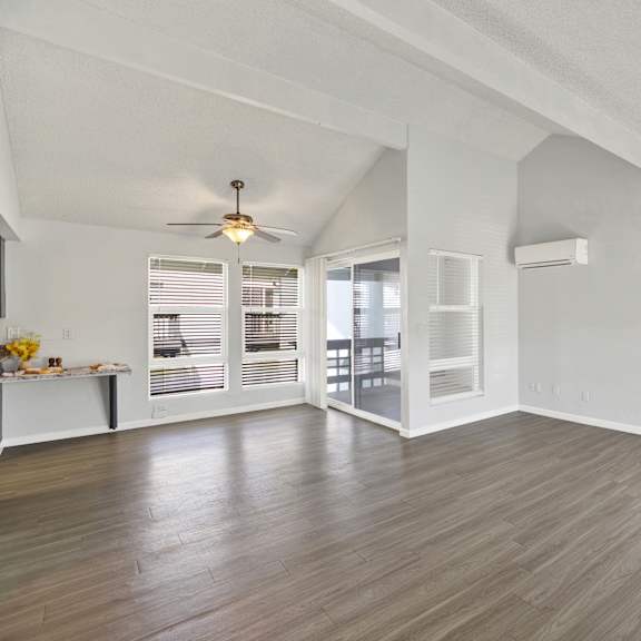 Thumbnail 17 of 18 A room with a ceiling fan and sliding glass doors.