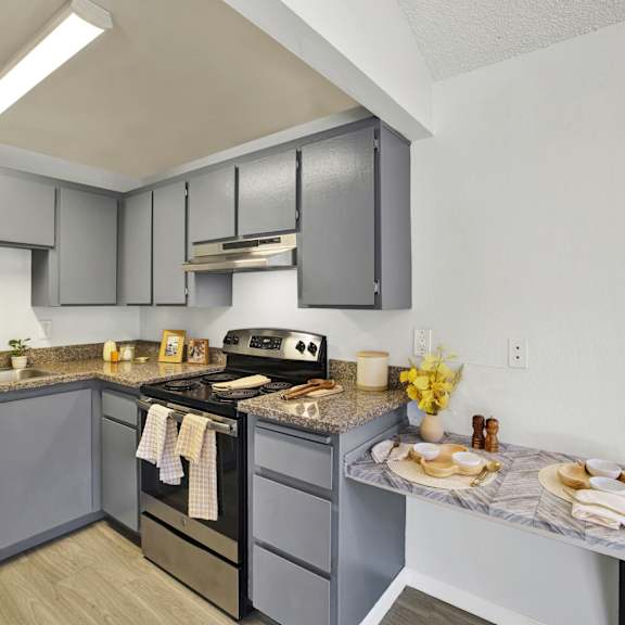 Thumbnail 6 of 18 A kitchen with a stove, oven, and refrigerator.