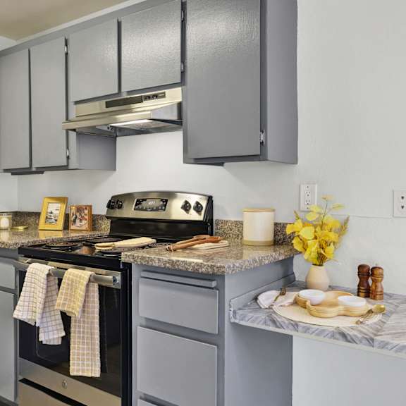 Thumbnail 5 of 18 A kitchen with a black stove top oven and a marble counter top.