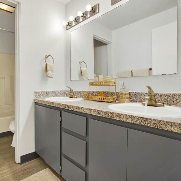 Thumbnail 7 of 18 A bathroom with a sink, mirror, and shower.