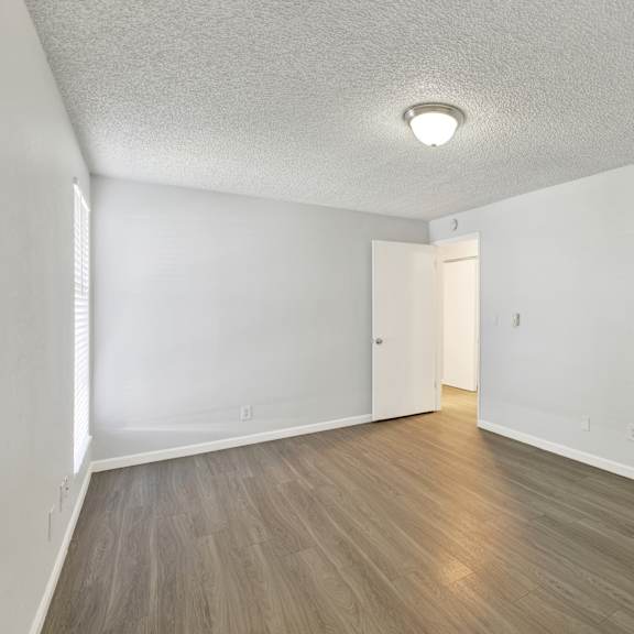 Thumbnail 4 of 18 A room with a light brown floor and a white ceiling with a light fixture.