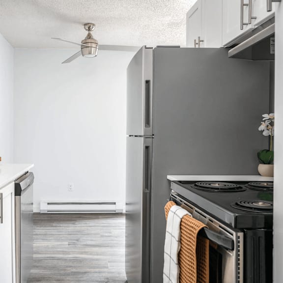 Thumbnail 2 of 3 A modern kitchen with a stainless steel refrigerator and a stove top oven.