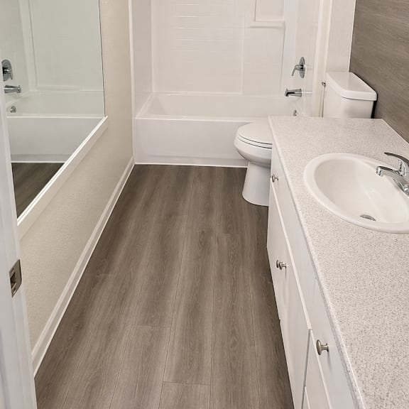 a white bathroom with a sink, toilet and bathtub.
