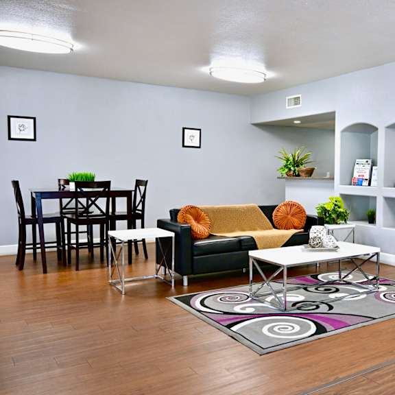 a living room with a black and white rug and a green couch.