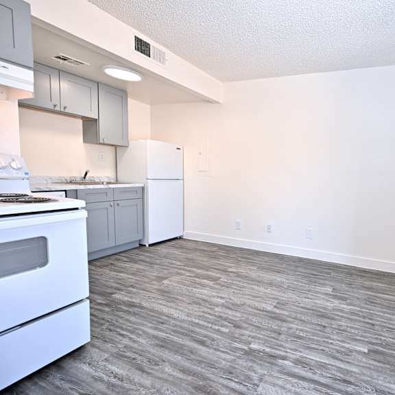 a kitchen with a white oven and a grey floor.