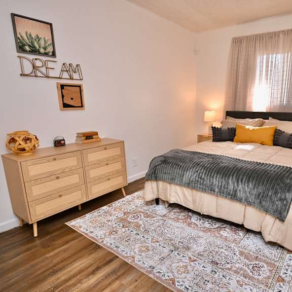 a bedroom with a bed, nightstands, and a rug.