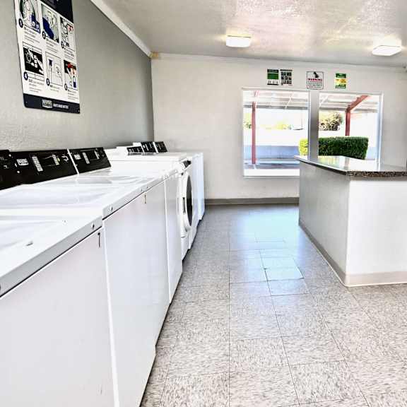 a laundromat with washers and dryers lined up.