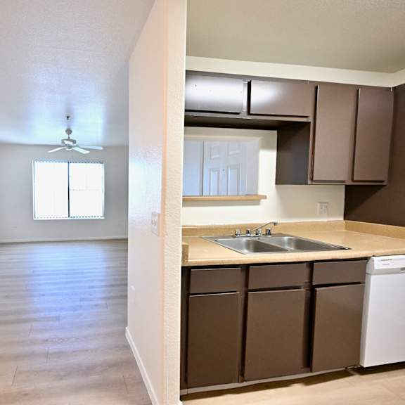 a kitchen with brown cabinets and a white dishwasher.