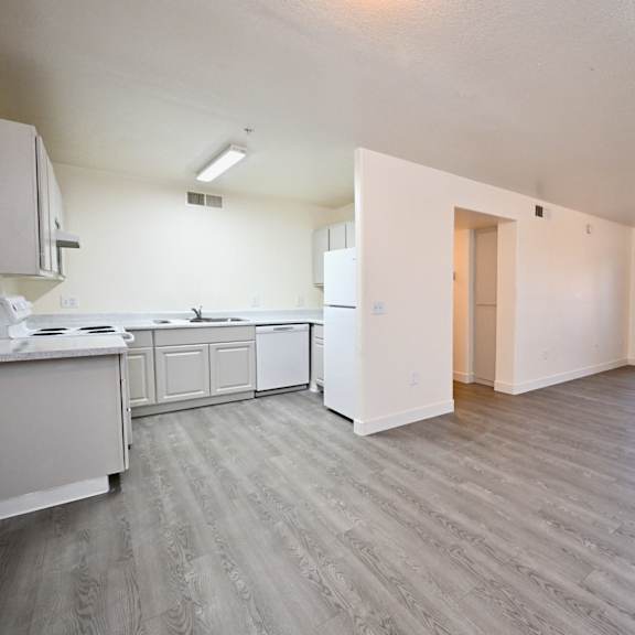 a kitchen with white cabinets and a dining table.