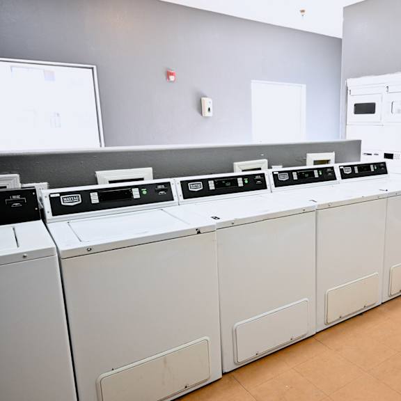 a row of white ovens are lined up in a room.