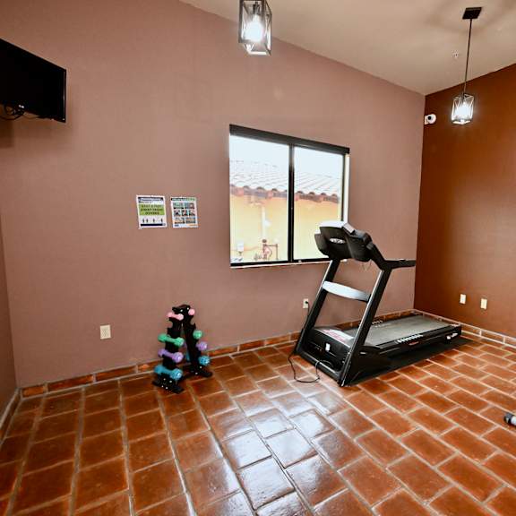 a room with a treadmill and exercise bike.