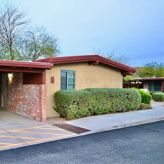 a building with a red roof and a parking lot in front.