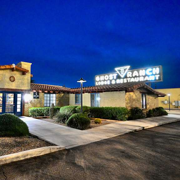 a building with a sign that says "ghost ranch" is lit up at night.
