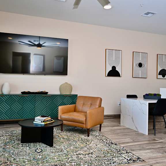 a living room with a green sofa, a brown armchair, and a black coffee table.