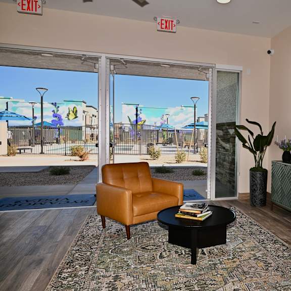 a room with a chair, a table, and a window with a view of the outside.