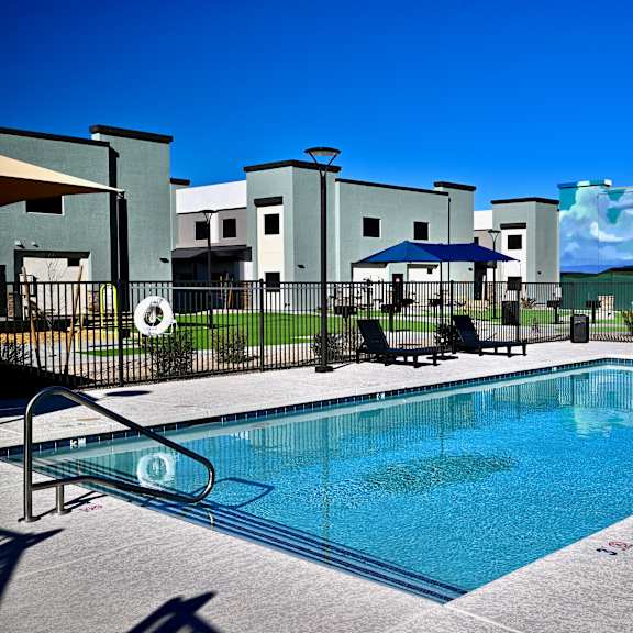 a swimming pool in front of a building with a mural on the wall.