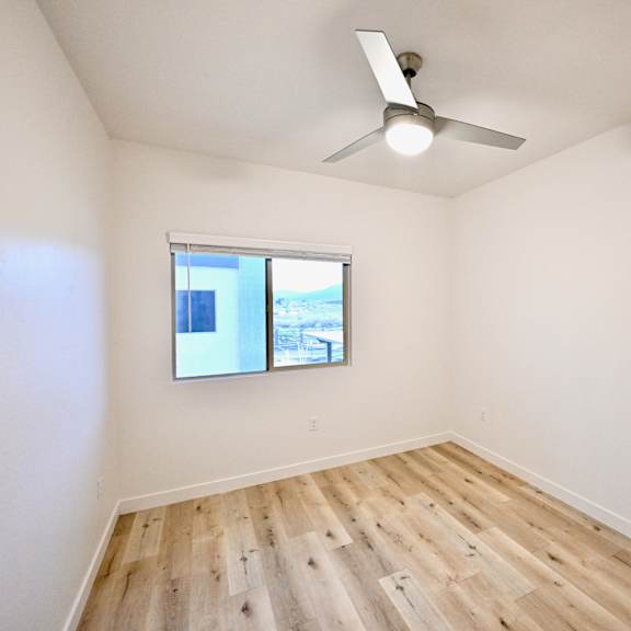 a room with a window and a ceiling fan.