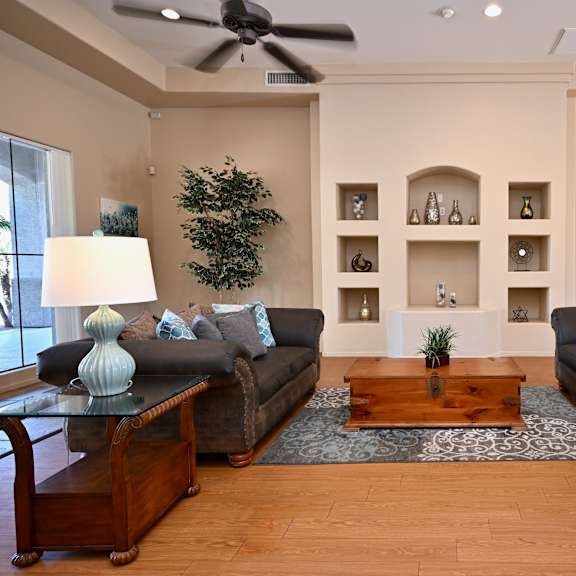 a living room with two couches, a coffee table, and a ceiling fan.