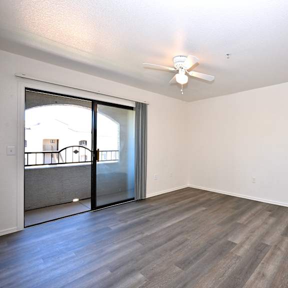 a room with a sliding glass door and a ceiling fan.