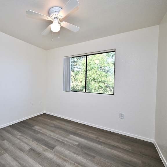 a room with a ceiling fan and a window.