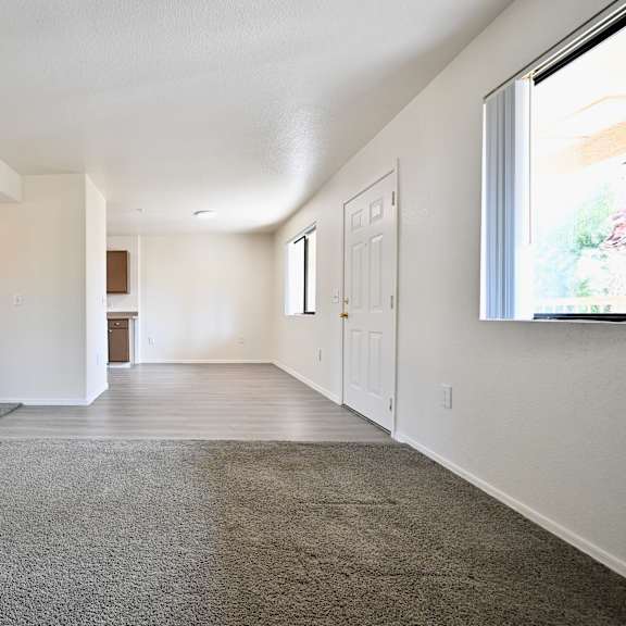 a spacious room with a carpeted floor and white walls.