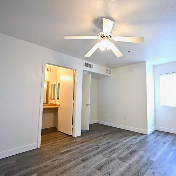 a room with a ceiling fan and a window.