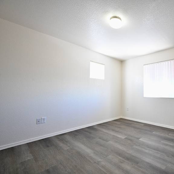 a room with a window and a wooden floor.