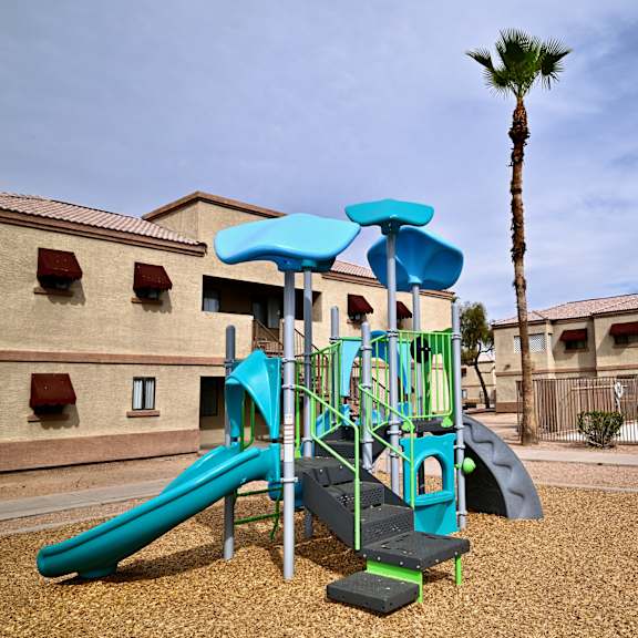 a playground with a blue slide and a green slide.