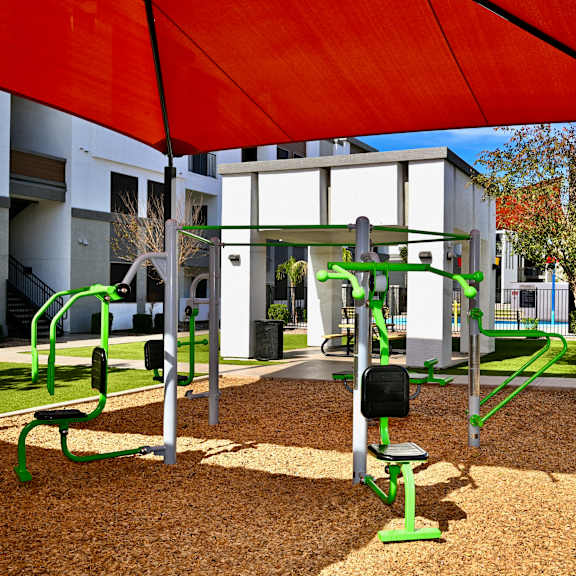 a playground with a red canopy and green equipment.