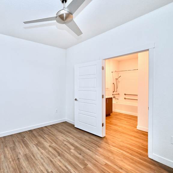 a room with a ceiling fan and a doorway leading to another room.