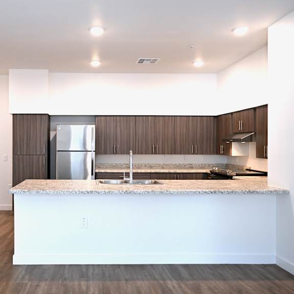 a kitchen with a white countertop and wooden cabinets.