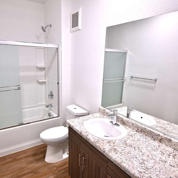 a bathroom with a sink, toilet, and a glass shower door.