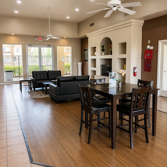 a modern living room with a black sofa set and a dining table with chairs.