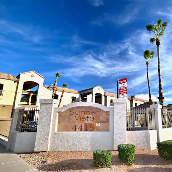 the image shows a gated community entrance with a sign that reads "sunrise vista 4415".