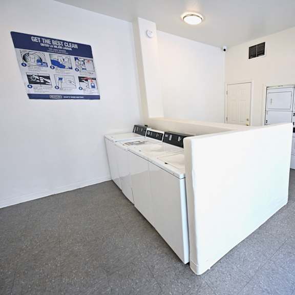 a white dryer is in a room with a sign on the wall.