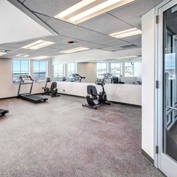 a gym with treadmills and elliptical machines.