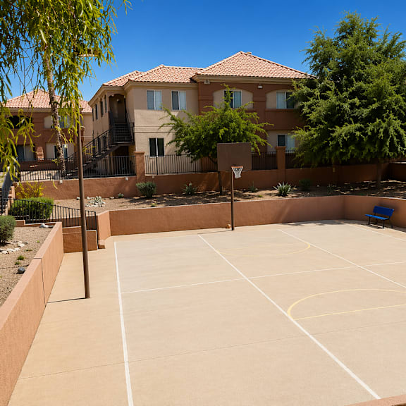 a basketball court is surrounded by houses and trees.