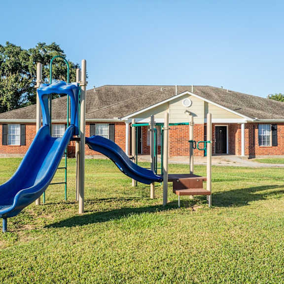 a blue slide in front of a small building.