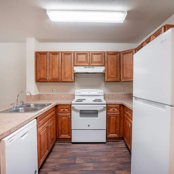 a kitchen with white appliances and wooden cabinets.