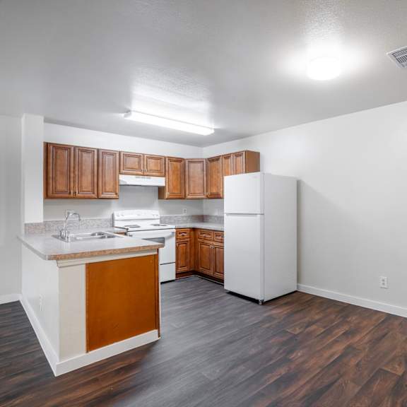 a kitchen with white appliances and wooden cabinets.