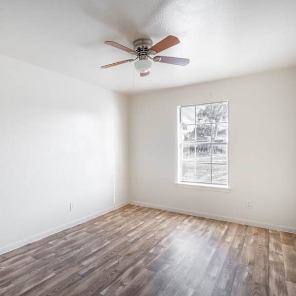 a room with a ceiling fan and a window.