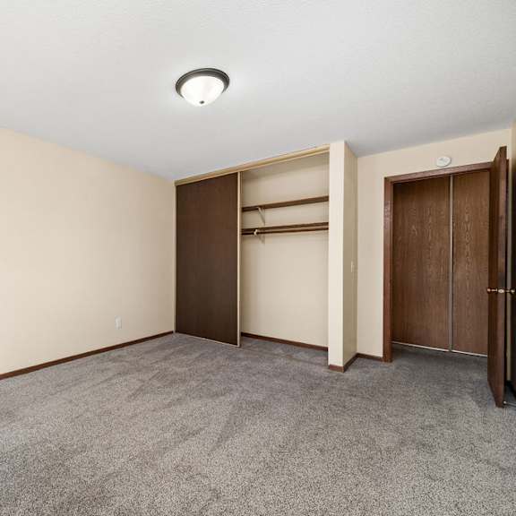 a room with a carpeted floor and a wall-mounted light fixture.