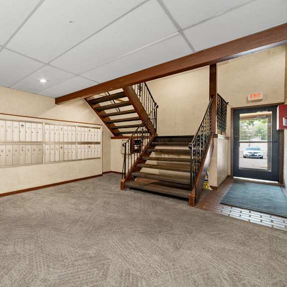 a hallway with a staircase and a calendar on the wall.