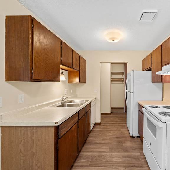 a kitchen with white appliances and wooden cabinets.